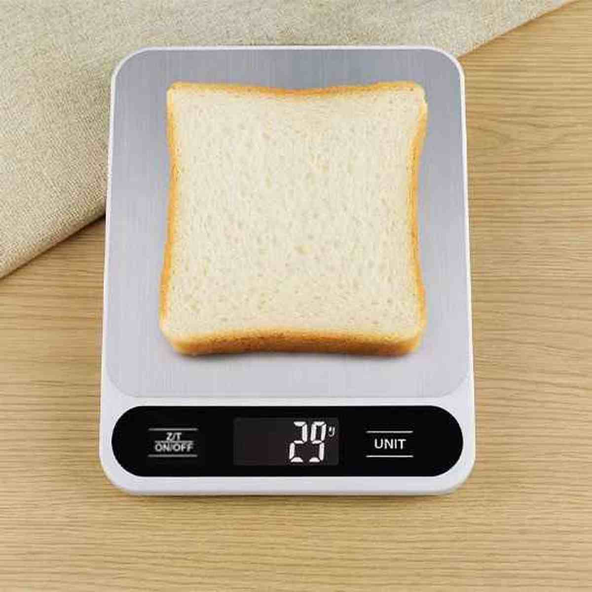 Tranche de pain de mie pesée sur une balance de cuisine Precision Elegance blanche et inox, affichant 29g sur l'écran LCD