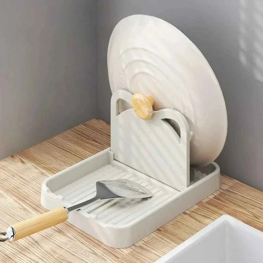 Support de couvercle blanc en silicone avec oreilles de chat supportant un couvercle de casserole et une spatule