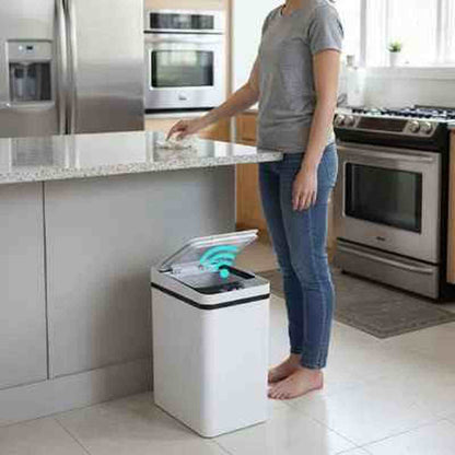 Poubelle automatique en acier inoxydable au design moderne et épuré intégrée dans une cuisine lumineuse avec îlot central