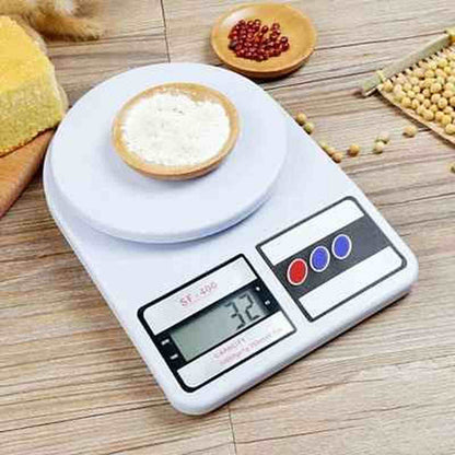 Balance de cuisine blanche Precision Pro affichant 32g avec une coupelle de poudre blanche et des grains disposés sur un plan de travail en bois.