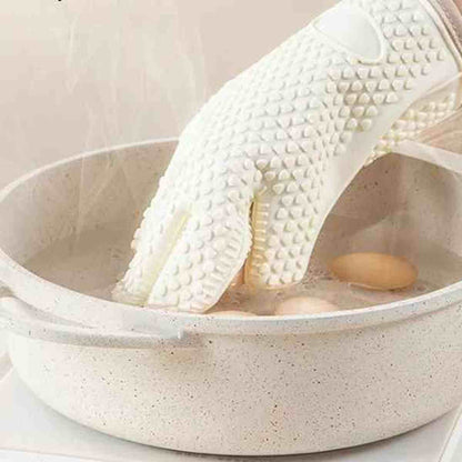 Gant de cuisine ThermoProtect en silicone blanc utilisé pour retirer des aliments d'une eau bouillante, démontrant son étanchéité et sa résistance thermique.