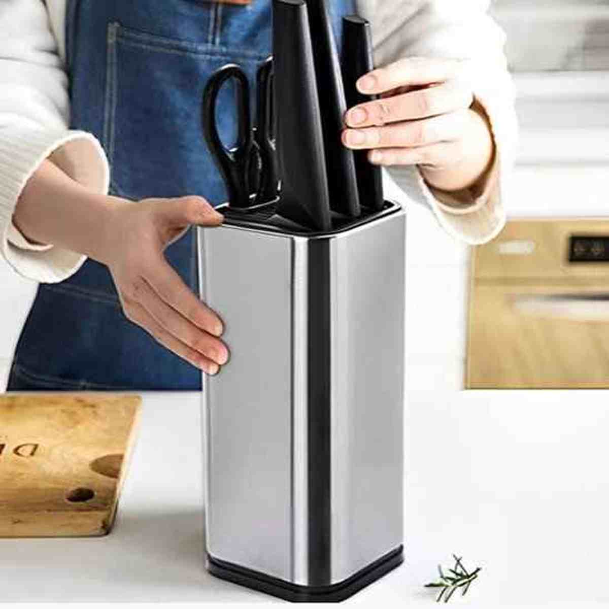 Utilisation du porte-couteaux en acier inoxydable pour ranger des couteaux de chef et des ciseaux de cuisine de façon organisée.