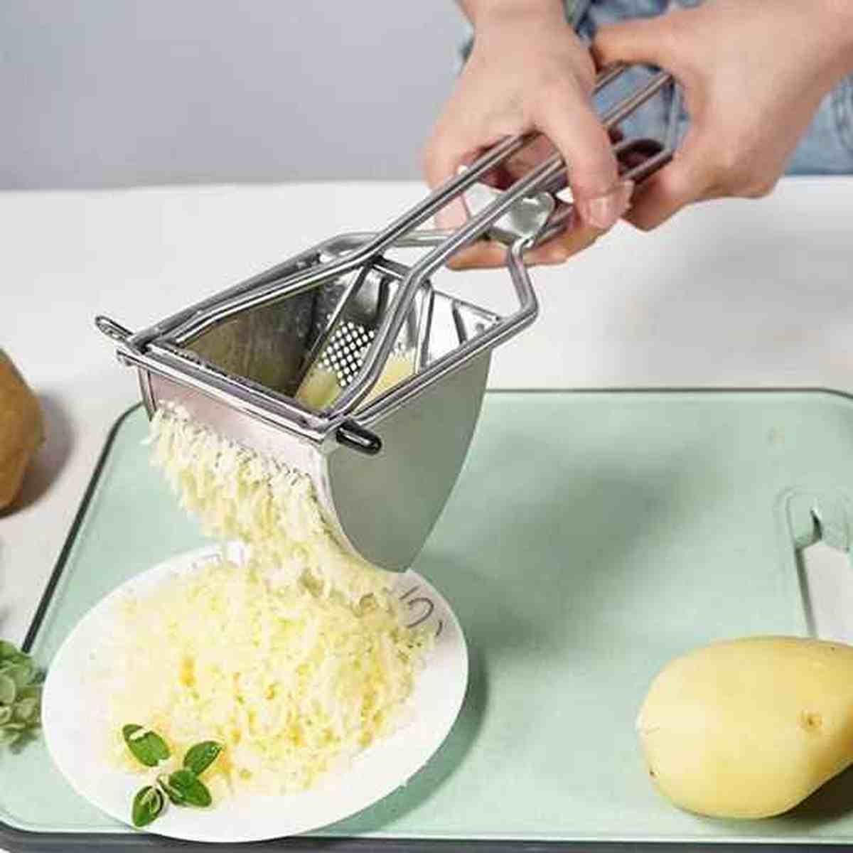 Presse-purée professionnel en inox extrudant finement des pommes de terre sur une assiette, montrant la robustesse du mécanisme à levier