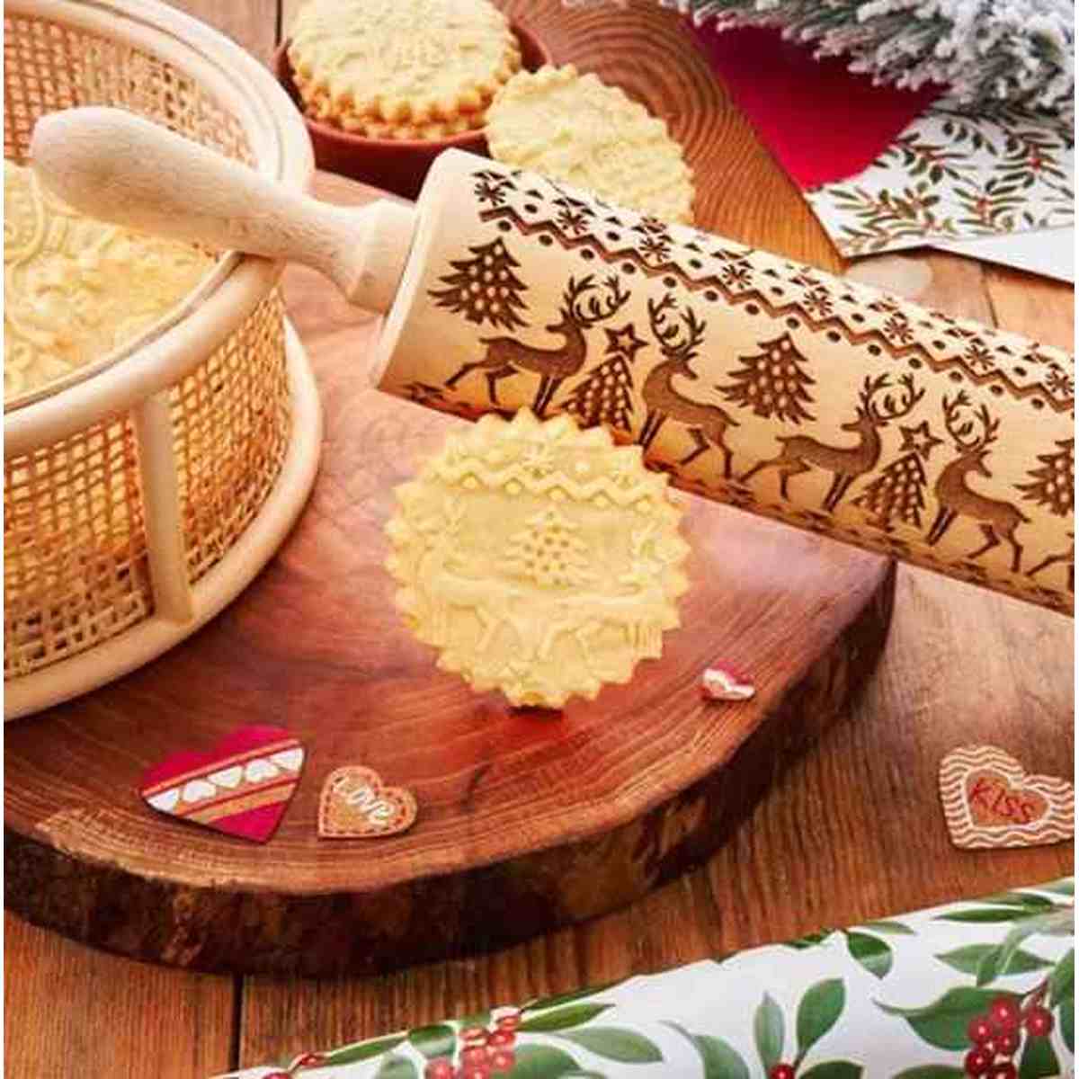 Rouleau à pâtisserie en bois massif gravé de motifs floraux artisanaux, montrant l'empreinte détaillée laissée sur une pâte à biscuits