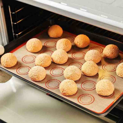 Tapis de cuisson PâtissiPro à l'intérieur du four avec des biscuits dorés en cours de cuisson, démontrant la résistance à la chaleur et la diffusion thermique
